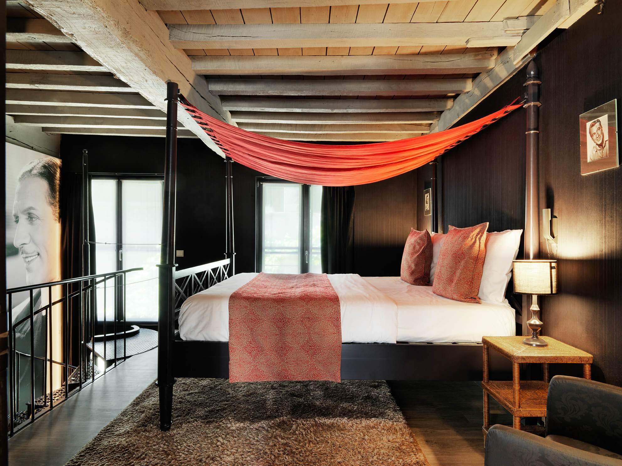 Hemelbed met rood baldakijn in een duplexkamer